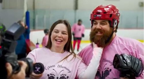 Amy and Chris Manning are wearing Hockey For Grace t-shirts at an ice rink, to promote their Emily‘s House fundraiser