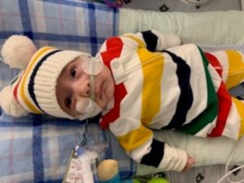 A photo of baby Ari in a crib with some medical equipment