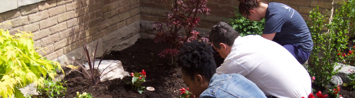 family members at Emily’s House Garden Memorial planting flowers in memory of a child