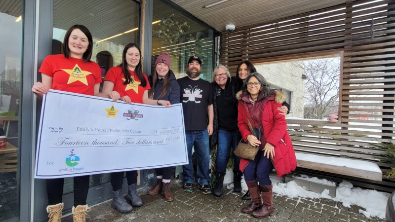 Group outside Emily's House with Cheque