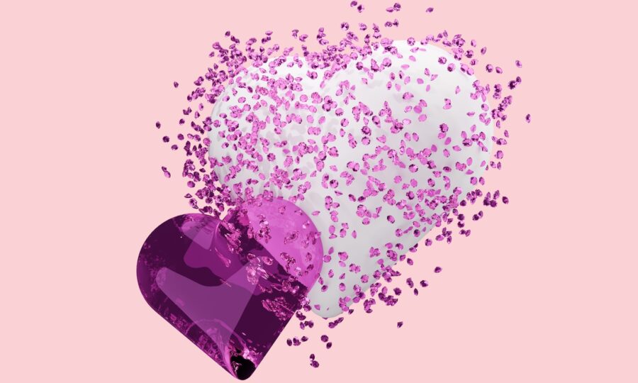 A heart shaped object with pink and white sprinkles